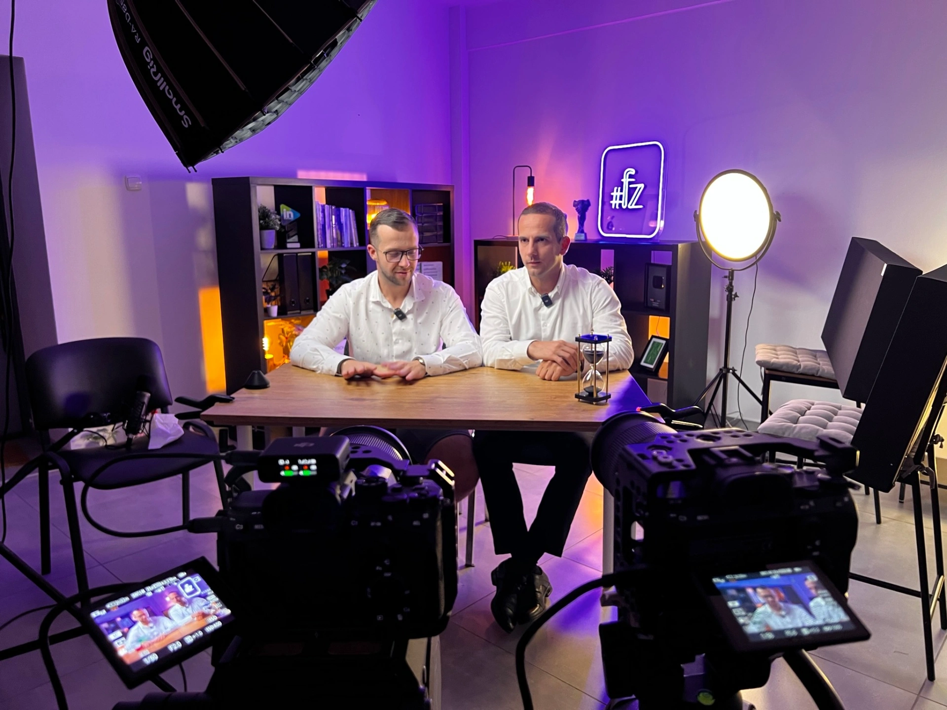 Dwóch gospodarzy przy stole z fioletowym oświetleniem